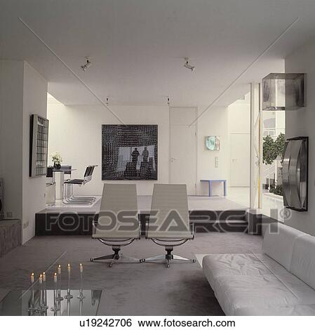 Stock Photograph - White sofa and chrome and leather chairs in openplan modern living room. Fotosearch