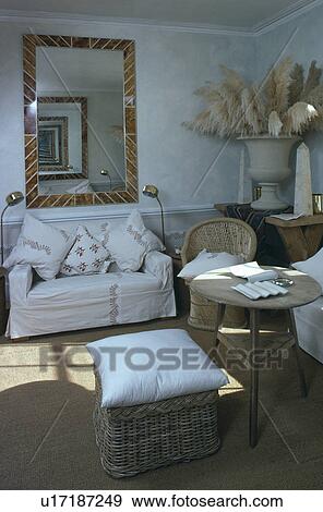 Stock Photo - White sofa below mirror in traditional living room. Fotosearch