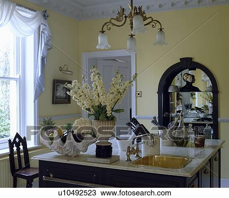 White stocks in vase beside large seashell on kitchen island unit with fitted brass sink in marble worktop View Large Photo Image Stock Image - White stocks in vase beside large seashell on kitchen island unit with fitted brass sink in marble worktop . Fotosearch