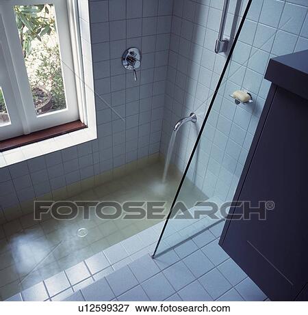 White tiled architectural bathroom with sunken bath and shower overlooking garden. View Large Photo Image Stock Photo - White tiled architectural bathroom with sunken bath and shower overlooking garden.. Fotosearch