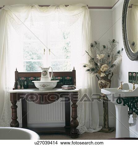 White voile curtains on window above antique marble-topped washstand with jug and basin in country bathroom View Large Photo Image Picture - White voile curtains on window above antique marble-topped washstand with jug and basin in country bathroom. Fotosearch