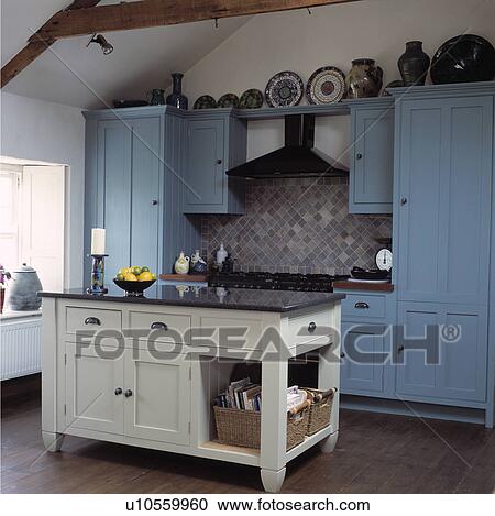 White wooden island unit with black granite top in country kitchen with pastel blue fitted cupboards View Large Photo Image Stock Image - White wooden island unit with black granite top in country kitchen with pastel blue fitted cupboards. Fotosearch