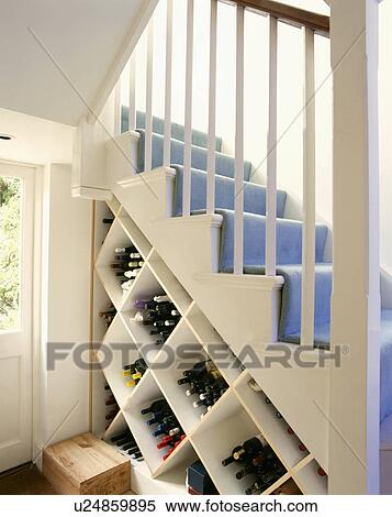 Wine bottles in cube storage under white staircase with blue carpet View Large Photo Image Stock Photography - Wine bottles in cube storage under white staircase with blue carpet. Fotosearch