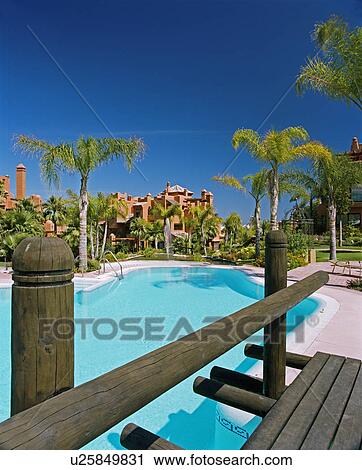 Wooden bridge and turquoise swimmingpool in Spanish holiday village View Large Photo Image Stock Image - Wooden bridge and turquoise swimmingpool in Spanish holiday village. Fotosearch