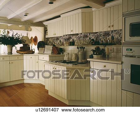 Wooden Flooring In Cottage Kitchen With Cream Wooden Cupboards
