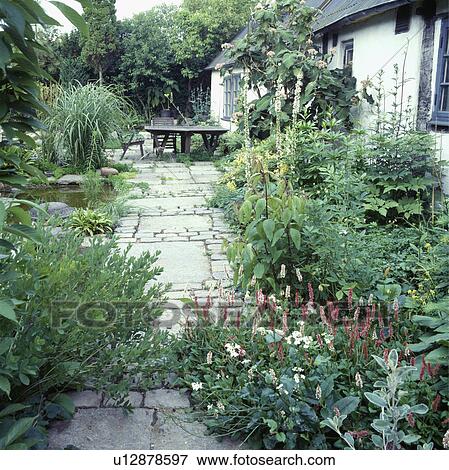Stock Photo -  Wooden furniture on patio in country garden in summer. Fotosearch