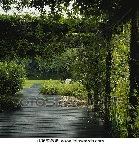 Wooden pergola in country garden in summer View Large Photo Image Stock Photo - Wooden pergola in country garden in summer. Fotosearch