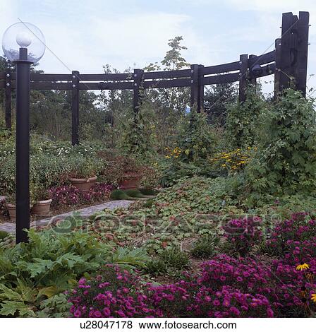 Stock Photo - Wooden pergola in country garden in summer. Fotosearch