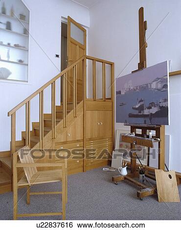 Wooden staircase with understairs storage cupboards and drawers in studio with easel and wooden chair View Large Photo Image Stock Photograph - Wooden staircase with understairs storage cupboards and drawers in studio with easel and wooden chair. Fotosearch