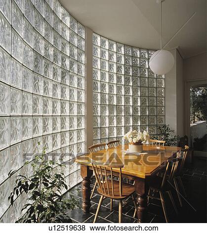 Wooden table and chairs in eighties dining room with curved glass brick wall View Large Photo Image Stock Photo - Wooden table and chairs in eighties dining room with curved glass brick wall. Fotosearch