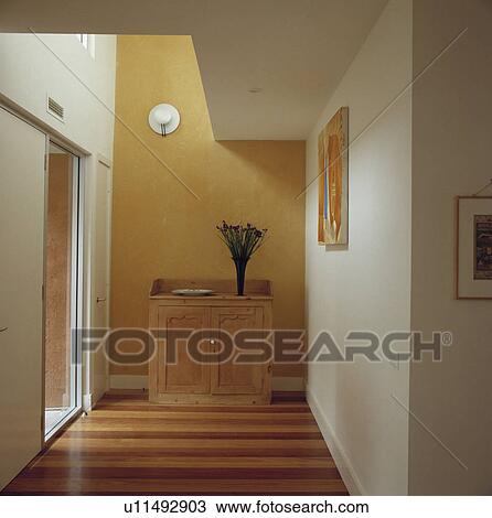 Stock Image - Yellow andwhite painted modern hallway with striped effect wooden board floor.. Fotosearch