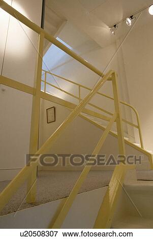Yellow metal bannisters in modern white staircase with ceiling spotlights View Large Photo Image Stock Photo - Yellow metal bannisters in modern white staircase with ceiling spotlights. Fotosearch