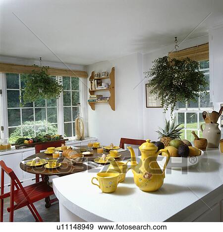 Yellow pottery coffee pot and cups on white worktop in country dining room with yellow plates on antique table View Large Photo Image Stock Photo - Yellow pottery coffee pot and cups on white worktop in country dining room with yellow plates on antique table. Fotosearch
