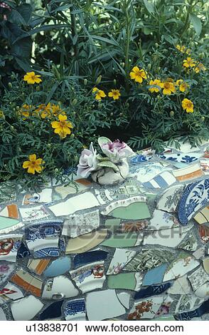 Yellow tagetes growing above mosaic wall made from colourful pieces of broken china View Large Photo Image Stock Image - Yellow tagetes growing above mosaic wall made from colourful pieces of broken china. Fotosearch