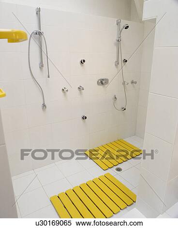 Yellow wooden mats in modern white shower room with double showers View Large Photo Image Stock Photography - Yellow wooden mats in modern white shower room with double showers. Fotosearch
