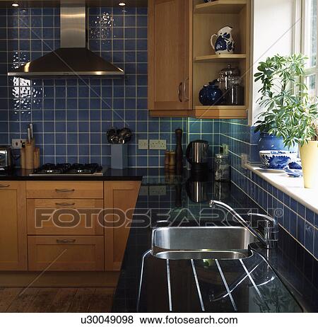 ステンレス スチール 流し 中に 花こう岩 Worktop 中に 現代 台所 で 薄い 木 フィットした 食器棚 と青 壁タイル 写真館 イメージ館 U Fotosearch