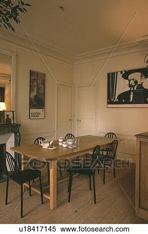 黒 椅子 そして 長方形 木製のテーブル 中に ８０代 食堂 で サイザル麻 カーペット そして 大きい 黒 白 壁の上の写真 ストックフォト 写真素材 U Fotosearch
