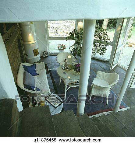 Stock Photo - Aerial view of living room extension with white Lloyd Loom furniture. Fotosearch