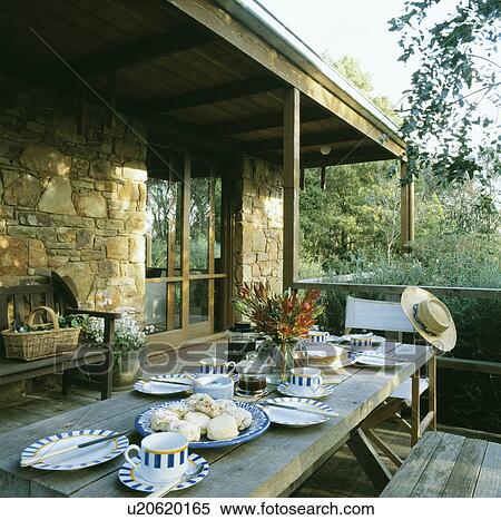 Alfresco meal on wooden verandah outside stone building View Large Photo Image Stock Photography - Alfresco meal on wooden verandah outside stone building. Fotosearch