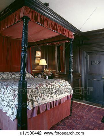 Antique carved wood fourposter bed with red canopy and crewelwork bedspread in country bedroom with panelled walls View Large Photo Image Stock Image - Antique carved wood fourposter bed with red canopy and crewelwork bedspread in country bedroom with panelled walls. Fotosearch