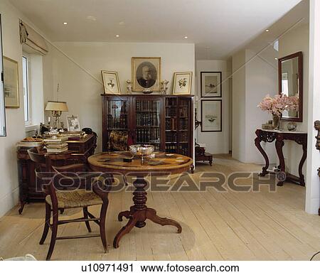 Antique table and chair in modern white hall dining room with wooden flooring View Large Photo Image Stock Image - Antique table and chair in modern white hall dining room with wooden flooring. Fotosearch