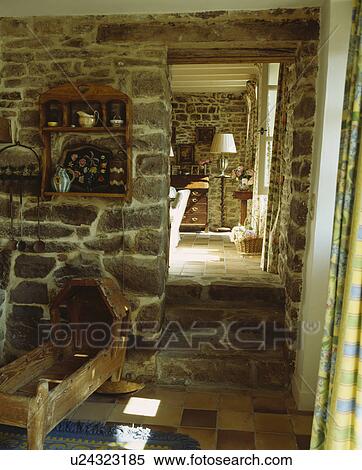 Antique wooden cradle in cottage hall with stone walls and floor and doorway to living room View Large Photo Image Stock Photography - Antique wooden cradle in cottage hall with stone walls and floor and doorway to living room. Fotosearch