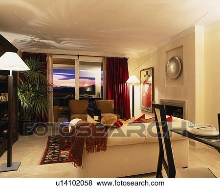 Apartment living and dining room with cream sofa and tall lamp  View Large Photo Image Stock Photo - Apartment living and dining room with cream sofa and tall lamp . Fotosearch