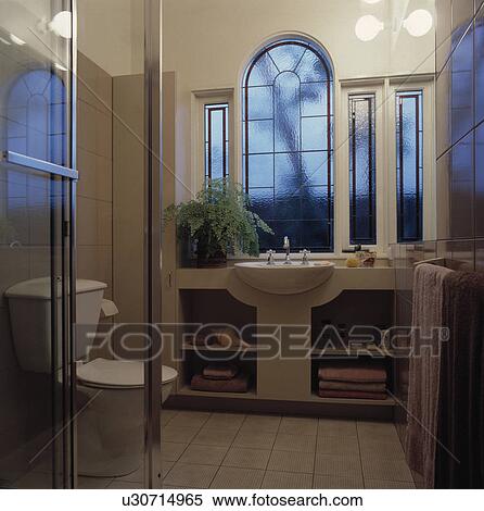 Arched opaque window above basin in vanity unit with open shelves in modern bathroom View Large Photo Image Stock Photography - Arched opaque window above basin in vanity unit with open shelves in modern bathroom. Fotosearch