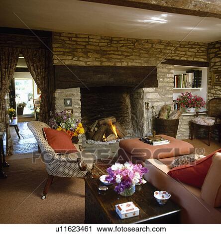 Stock Image - Armchair beside fireplace in traditional living room. Fotosearch