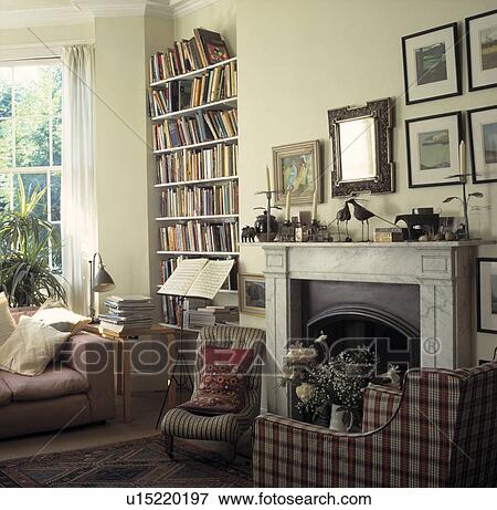 Armchair Beside Fireplace In Traditional Living Room Stock Photo