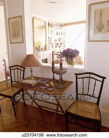 Bamboo table between antique chairs with cane seats below large aperture in hall wall View Large Photo Image Stock Photograph - Bamboo table between antique chairs with cane seats below large aperture in hall wall. Fotosearch
