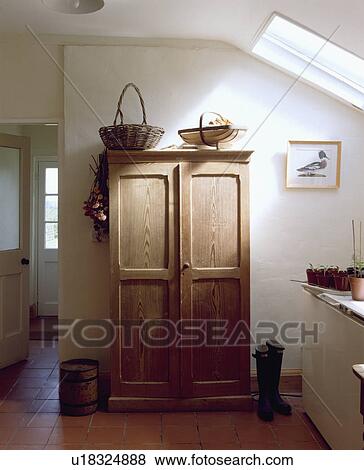 Basket and wooden trug on simple wooden cupboard in white kitchen View Large Photo Image Stock Photo - Basket and wooden trug on simple wooden cupboard in white kitchen. Fotosearch