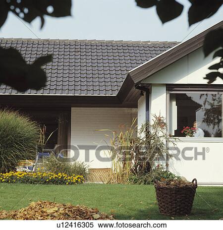 Stock Photography - Basket on lawn in front of modern white bungalow in the country. Fotosearch