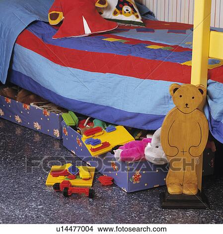 Bed with red+blue striped duvet above colourful storage drawers with toys View Large Photo Image Picture - Bed with red+blue striped duvet above colourful storage drawers with toys. Fotosearch