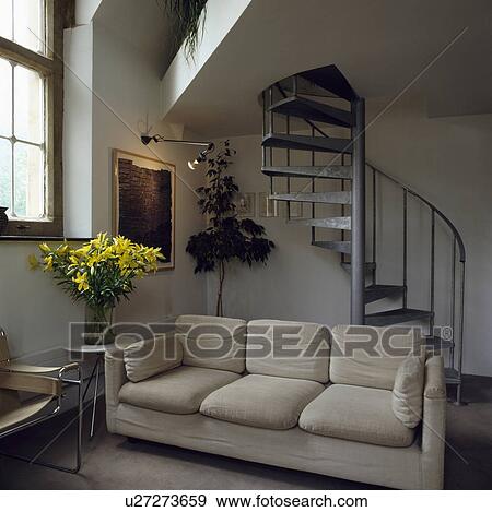 Beige sofa in living room with metal spiral staircase View Large Photo Image Stock Photo - Beige sofa in living room with metal spiral staircase. Fotosearch