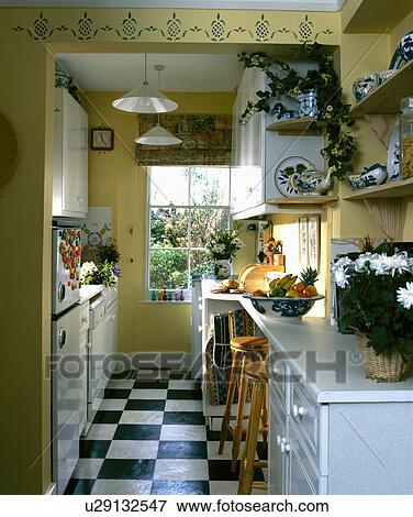 Black And White Vinyl Floor Tiles In Yellow Galley Kitchen With Picture Black And White Vinyl Floor Tiles In Yellow Galley Kitchen With Stencilling Above Doorway