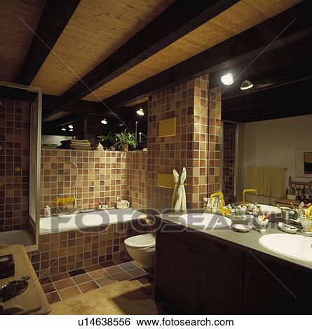 Black beams on wooden ceiling in neutral giled bathroom with double basins in fitted vanity unit View Large Photo Image Stock Photograph - Black beams on wooden ceiling in neutral giled bathroom with double basins in fitted vanity unit. Fotosearch