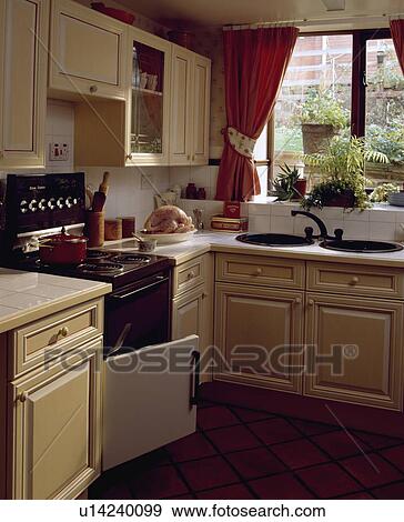 Black oven with door open in small kitchen with white tiled worktops on wooden fitted cupboards View Large Photo Image Stock Photo - Black oven with door open in small kitchen with white tiled worktops on wooden fitted cupboards. Fotosearch