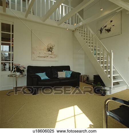 Black sofa in modern white living room with white staircase View Large Photo Image Stock Photography - Black sofa in modern white living room with white staircase. Fotosearch