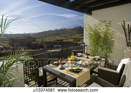 Black wicker chairs and table laid for lunch on balcony of modern apartment in Spain View Large Photo Image Stock Image - Black wicker chairs and table laid for lunch on balcony of modern apartment in Spain. Fotosearch