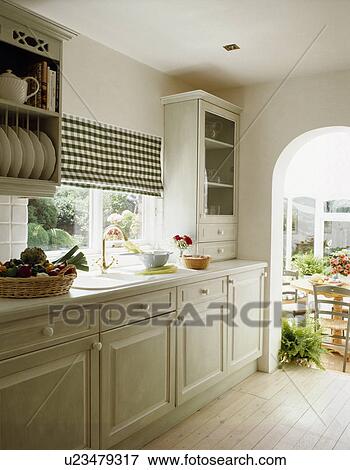 Black+white checked blind in pale grey kitchen with wooden flooring and doorway to conservatory View Large Photo Image Stock Photo - Black+white checked blind in pale grey kitchen with wooden flooring and doorway to conservatory. Fotosearch