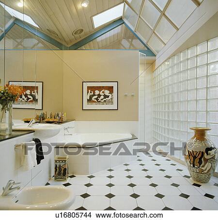 Black+white chequerboard floor tiles in modern bathroom extension with glass brick wall and corner bath View Large Photo Image Picture - Black+white chequerboard floor tiles in modern bathroom extension with glass brick wall and corner bath. Fotosearch