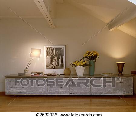 Black+white framed poster on metal cupboard unit in modern living room View Large Photo Image Stock Photograph - Black+white framed poster on metal cupboard unit in modern living room. Fotosearch