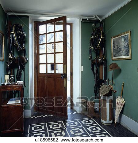 Black+white tiled floor in green hall with bridles hanging on either side of open half-glazed door View Large Photo Image Stock Image - Black+white tiled floor in green hall with bridles hanging on either side of open half-glazed door. Fotosearch