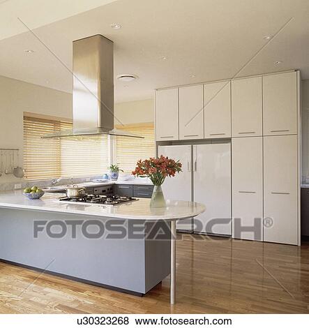 Blanc Worktops Sur Gris Péninsulaire Unité Dans Moderne Blanc Cuisine à Grand Congélateur Réfrigérateur Dans Mur De Ajusté Armoires