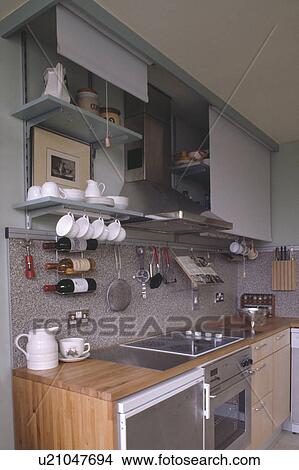 Blinds above shelves in small spacesaving kitchen with wine storage on granite splashback View Large Photo Image Picture - Blinds above shelves in small spacesaving kitchen with wine storage on granite splashback . Fotosearch