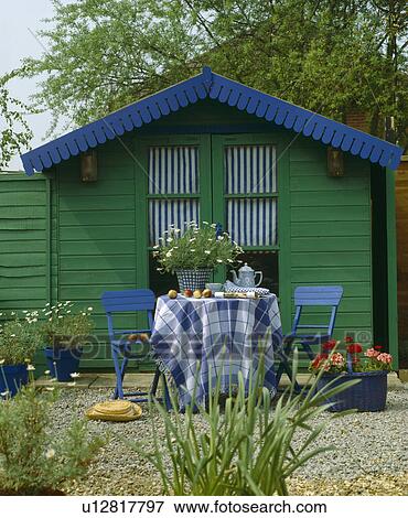 Blue chairs and table with checked cloth in front of blue and green painted wooden garden shed View Large Photo Image Stock Photo - Blue chairs and table with checked cloth in front of blue and green painted wooden garden shed . Fotosearch