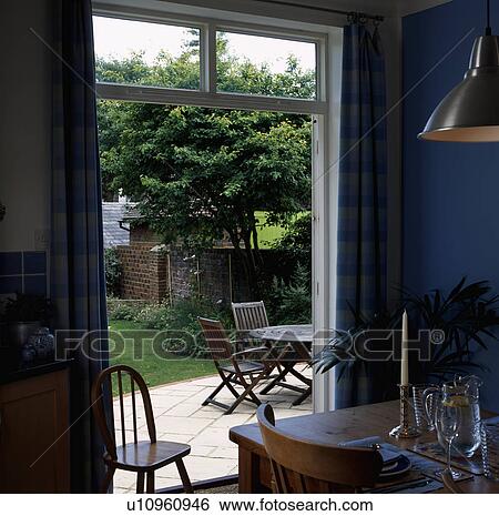 Blue dining room with open doorway to garden and patio View Large Photo Image Stock Photograph - Blue dining room with open doorway to garden and patio. Fotosearch