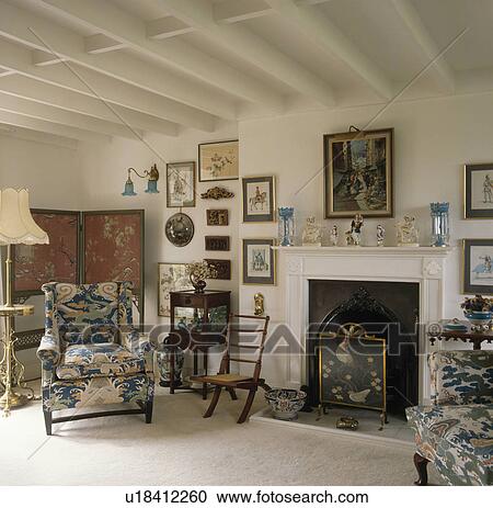 Blue patterned armchair in country living room with white beamed ceiling and firescreen in fireplace View Large Photo Image Stock Image - Blue patterned armchair in country living room with white beamed ceiling and firescreen in fireplace. Fotosearch