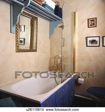 Blue shelf above bath with blue panel in bathroom with paint effect spongeing walls View Large Photo Image Picture - Blue shelf above bath with blue panel in bathroom with paint effect spongeing walls. Fotosearch
